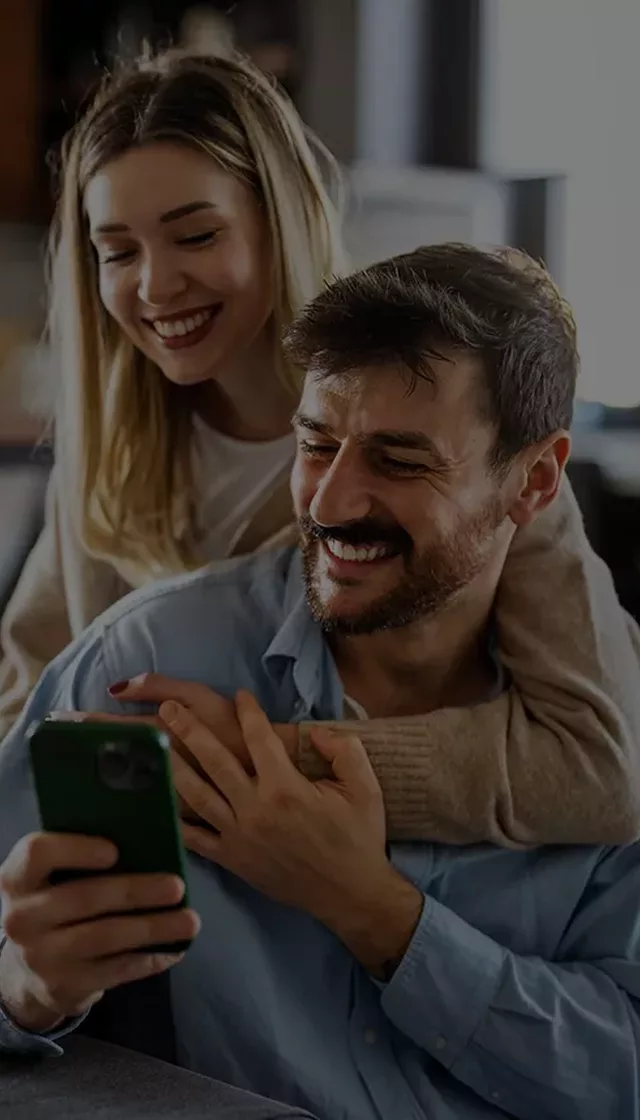 Couple using smartphone to buy life insurance for parents